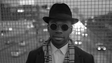 Young-Man-with-African-American-Ethnicity-Wearing-Old-Classic-Look.-Having-Fun-in-the-Big-City-with-Sunglasses,-Hat-and-Scarf.