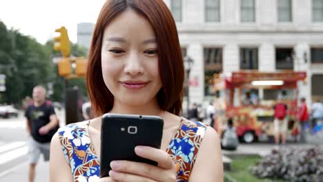 Hermosa-mujer-China-enviar-mensajes-de-texto-y-hablando-con-el-teléfono-en-la-ciudad.-Ser-feliz,-sonreír-y-divertirse.