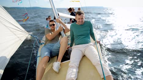 Men-sitting-on-modern-yacht-posing-and-smiling-at-camera