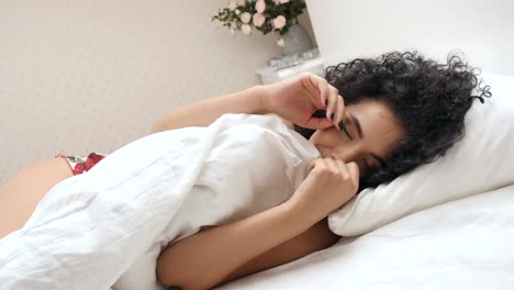 Happy-woman-poses-to-camera-in-the-bed