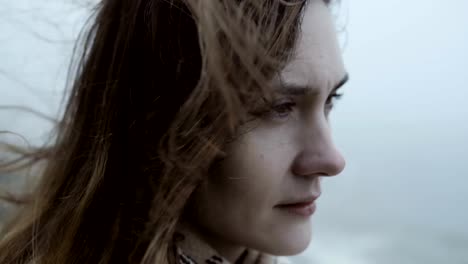 Close-up-view-of-young-thoughtful-woman,-looking-sad.-Pensive-attractive-female-in-fog,-hair-waves-on-the-wind