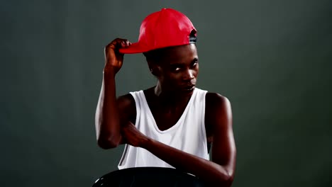 Androgyne-Mann-posiert-mit-roter-Mütze