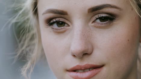 Nahaufnahme-Gesicht-süß-lächelnde-Frau,-Kamera-in-der-Stadt-suchen.-Wind-weht-ihr-Haar.