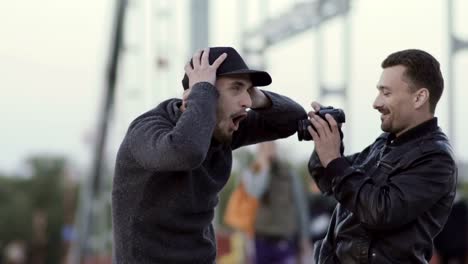 Two-men-have-fun-at-the-bridge-with-camera