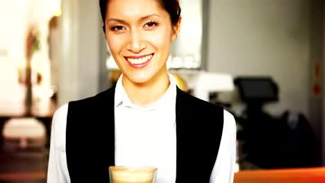 Retrato-de-sonriente-bandeja-de-retención-de-camarera-de-vidrio-café