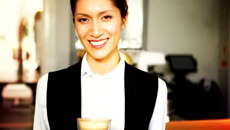 Portrait-of-smiling-waitress-holding-tray-of-coffee-glass