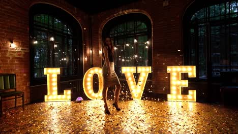 Beautiful-girl-posing-against-a-background-of-shining-letters