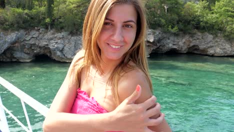 Close-up-Portrait-Of-Young-Woman-Smiling-While-Standing-On-Azure-Sea-Background