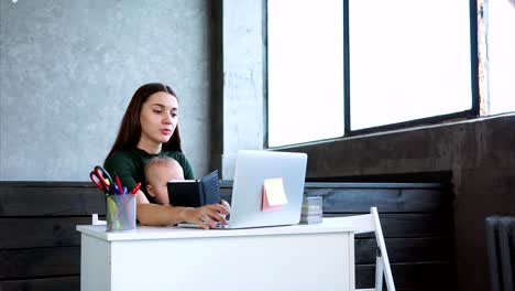 Woman-working-at-office-with-her-child