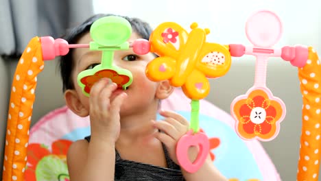 niedliche-Baby-Boy-mit-Hand-spielen-Spielzeug-in-den-Mund-gelegt