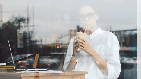 Woman-sipping-drink-at-cafe