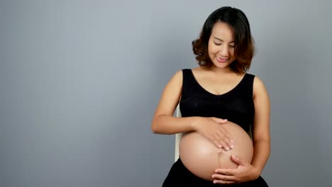 Beautiful-pregnant-woman-on-gray-background