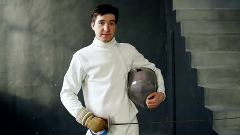 Portrait-of-young-fencer-man-smiling-and-looking-into-camera-indoors