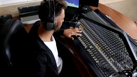 radio-presenter-with-headphones-on-head-sit-on-chair-and-speaks-in-microphone