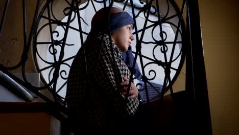 portrait-of-sad-woman-suffering-from-cancer-at-the-window-greets-someone-feebly