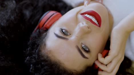 Portrait-of-young-girl-with-red-lips-enjoys-music-in-headphones