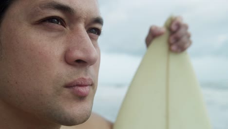 Upper-body-male-Hawaiian-surfer-surfboard-on-beach