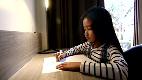 4K-Asian-little-girl-drawing-on-the-table-shot-by-wide-angle-lens