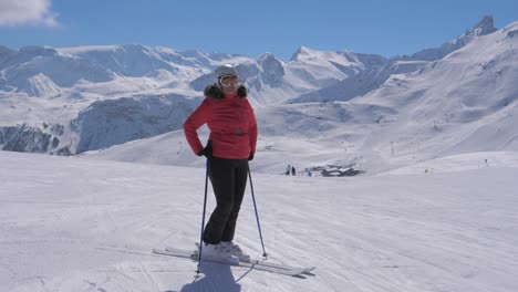 Sporty-woman-skier-stands-on-the-slope-of-the-mountain-ski-resort