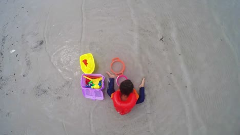 Kinder-spielen-Spielzeug-am-Strand.-Ansicht-von-oben