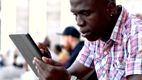 Portrait-of-young-American-black-man-using--the-digital-tablet---outdoor