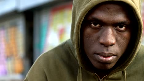 Serious-Handsome-young-black-man-staring-at-camera--urban-background