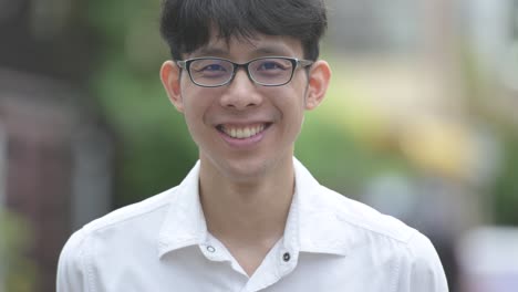 Young-happy-Asian-businessman-smiling-in-the-streets-outdoors