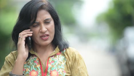 Mature-beautiful-Indian-woman-talking-on-the-phone-in-the-streets-outdoors