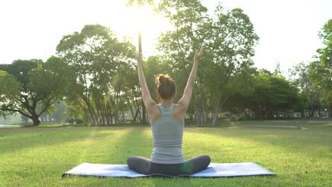 Junge-asiatische-Frau-Yoga-im-Freien-bleiben-Sie-ruhig-und-meditiert-beim-Üben-von-Yoga,-die-innere-Ruhe-zu-erkunden.-Yoga-und-Meditation-haben-gute-Vorteile-für-die-Gesundheit.-Yoga-Sport-und-gesunde-Lifestyle-Konzept.