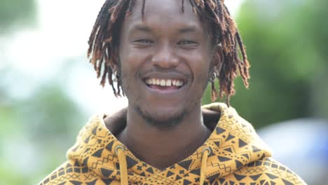 Young-happy-handsome-African-man-smiling-in-the-streets-outdoors