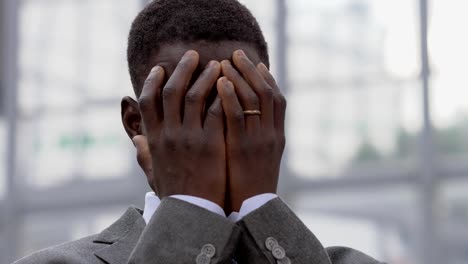 desperate-black-african-business-man-putting-his-hands-on-face--outdoor