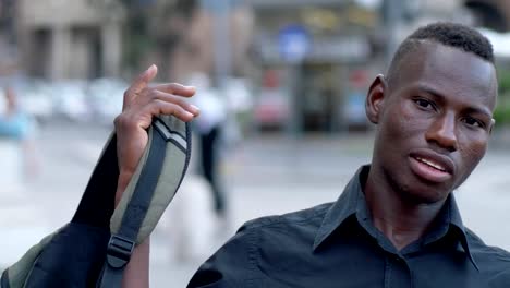 Young-black-African-student-puts-his-backpack-on-his-shoulder---outdoor