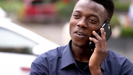 close-up-on-Relaxed-young-african-man-taking-by-phone--outdoor