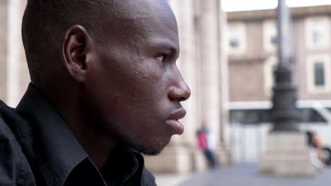 Thoughtful-young-black-man-looking-ahead-outdoor--profile