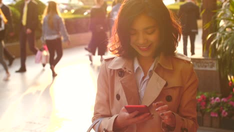 young-asian-woman-using-mobile-phone-in-the-city