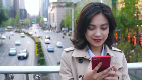 Mujer-joven-usando-teléfono-inteligente-en-la-ciudad