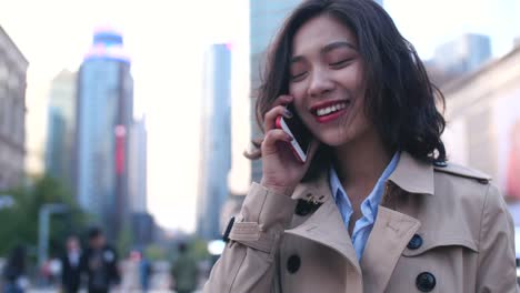 Pretty-happy-young-asian-woman-talking-on-the-mobile-phone