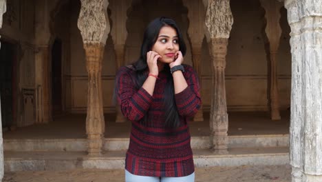 Beautiful-young-lady-looking-at-camera-POV-gets-scared-afraid-shocked-disgust-sudden-fun-around-mid-shot-handheld-looking-at-camera-for-demon-shock-joke-kidding-play-games-at-a-sacred-temple-complex