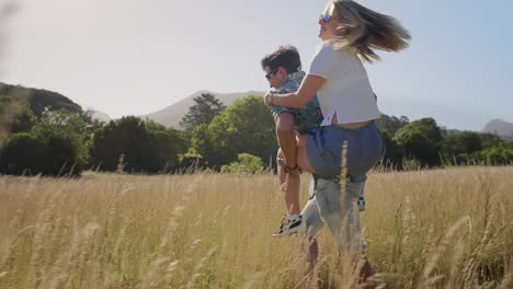 Piggyback-couple-laughing-in-long-grass-field-in-love