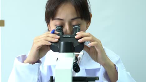 Mujeres-científicas-mirando-a-través-de-microscopio-y-observar-en-moderno-laboratorio-o-centro-médico.-Concepto-de-ciencia,-industria-de-desarrollo-y-laboratorio-de-pruebas.