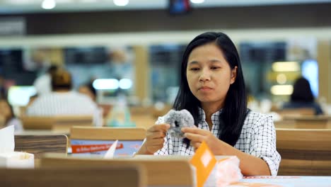 Asiatische-Frauen-sind-Donuts-gerne-im-Restaurant-Essen.