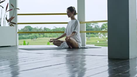 Frau,-meditieren,-beim-Sitzen-auf-Yoga-Matte