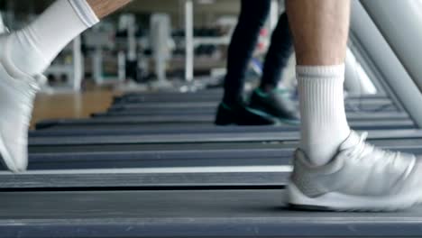 Un-chico-sin-camiseta-en-el-gimnasio,-entrena-su-cuerpo-para-mantenerse-en-forma-y-han-definido-los-músculos.-El-atleta-provoca-fatiga-y-cargas-pesadas.