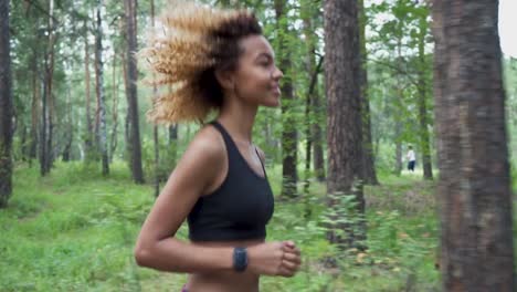 joven-hermosa-chica-negra-con-el-pelo-rizado-con-su-reloj-inteligente-para-correr