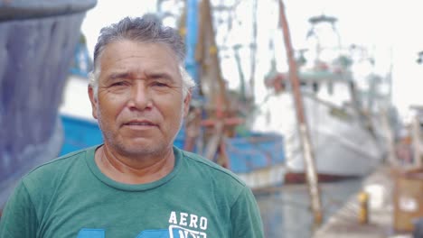 Close-up-portrait-of-an-older-man-of-hispanic-heritage-standing-in-front-of-a-boatyard-in-Mexico