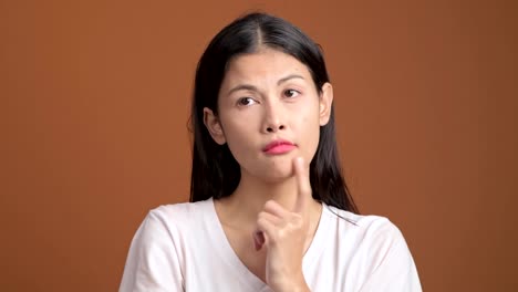 Denken-Frau-isoliert.-Porträt-von-Asiatin-im-weißen-T-shirt-denken-schwer-und-aufgeregt,-um-eine-Lösung-zu-finden,-Blick-in-die-Kamera.