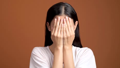 Mädchen-spielen-Versteckspiel-Porträt.-Asiatische-Frau-in-weißem-T-shirt-bedecken-ihre-Augen-mit-ihren-Händen-für-verstecken-und-suchen.