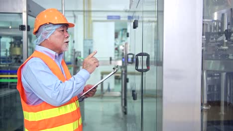 Qualitätskontrolle-in-der-Fabrik.-Hochrangige-chinesische-Qualitätssicherungs-Team-Inspektion-einer-Flüssigkeit-Flasche-Füllmaschine-im-Werk-mit-TQM,-TPM-Methode.-Exzellenz-Fertigungskonzept.