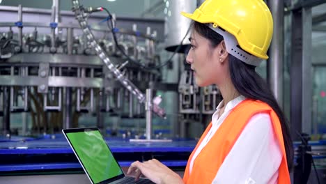 Mujer-ingeniero-industrial-en-el-trabajo-en-la-fábrica.-Hermosa-joven-ingeniero-chino-trabajando-en-fábrica-grande.-Con-casco-y-chaqueta.-Máquina-automática-de-alta-tecnología-en-segundo-plano.