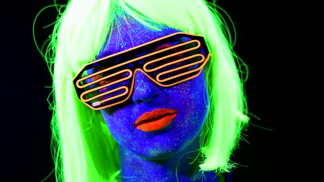 Woman-with-UV-face-paint,-wig,-UV-glasses,-glowing-clothing-portrait,-face-close-up-of-make-up.-Caucasian-woman.-.